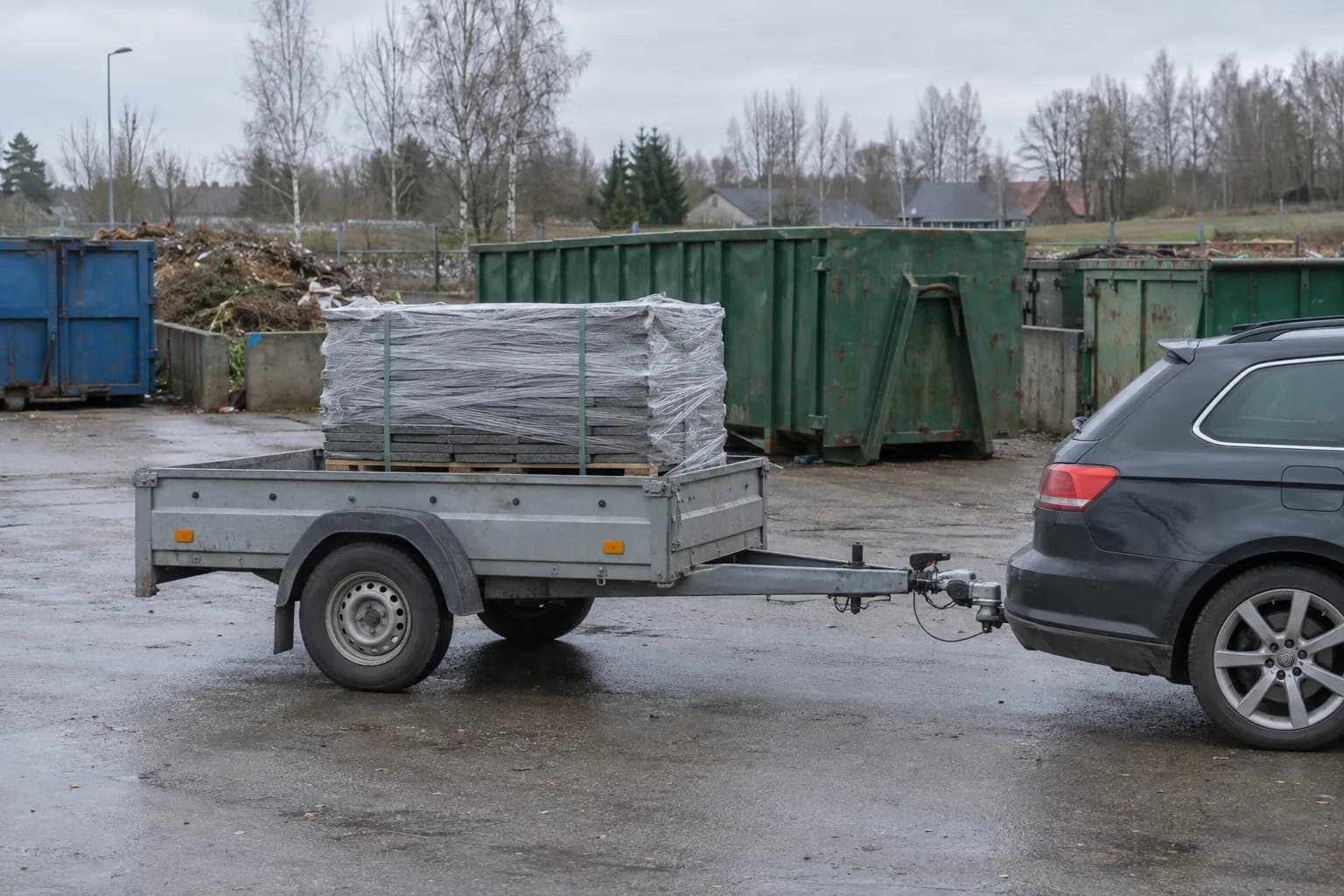 Lengvojo automobilio priekaba su plėvele apvyniota šiferio palete savivaldybės atliekų surinkimo aikštelėje